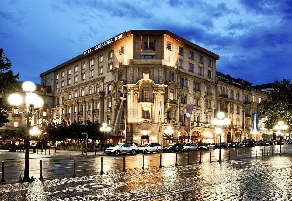 "a large building with a sign that reads "" hotel m . on "". several cars parked in front of the building" at Hotel Nassauer Hof