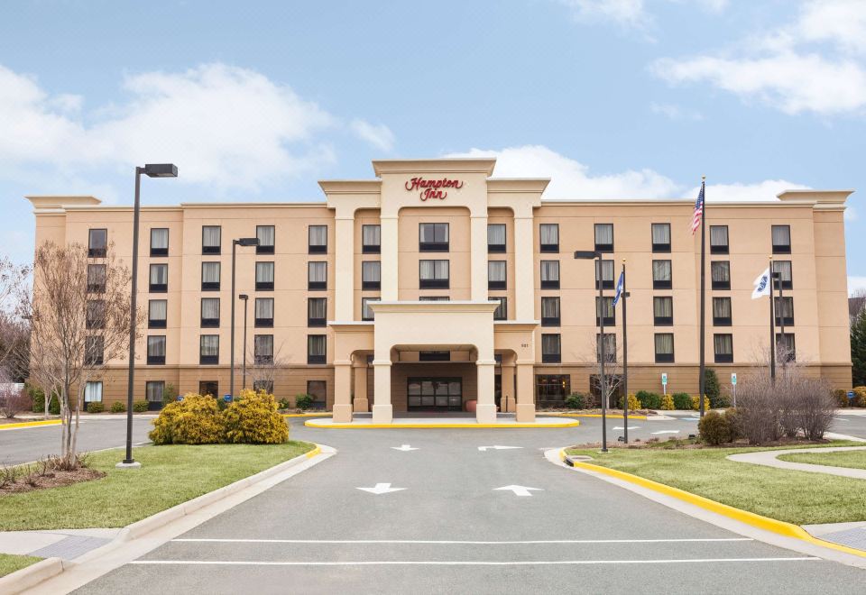 "a large , tan - colored hampton inn hotel with the name "" hampton inn "" prominently displayed on its front" at Hampton Inn Warrenton, VA