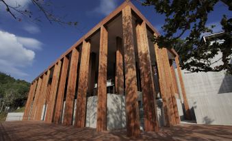 a large , modern building with wooden slats and a clear blue sky in the background at The Naka Phuket, a member of Design Hotels