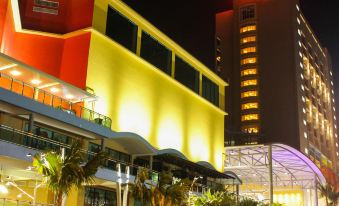 "a large building with a red sign that says "" hotel "" is lit up at night" at Palm Seremban Hotel