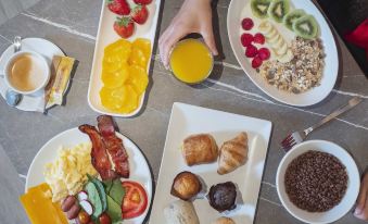 A table filled with food and drinks is available at the hotel bistro in Brussels, Belgium at Arcelon Hotel