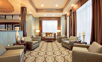 a well - decorated hotel lobby with various seating options , including couches and chairs , as well as a dining table at Hilton Garden Inn Irvine Spectrum Lake Forest