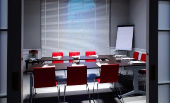 a conference room with a long table and chairs , a whiteboard , and a window with blinds at Palazzo Castri 1874 Hotel & Spa