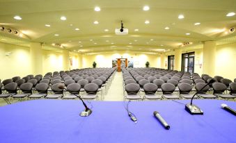 a large , empty conference room with multiple chairs and microphones set up for a meeting or event at Hotel San Rocco