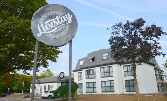 "a large hotel with a round sign that says "" liscstay "" in front of it" at Quellenhof