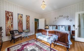 a spacious bedroom with two twin beds , one on the left side of the room and the other on the right side at Hillcrest Mansion Inn