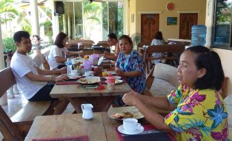 a group of people gathered around a dining table , enjoying a meal together while sitting down at Stella Resort