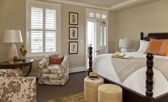 a modern bedroom with white walls , large windows , and a comfortable bed , along with comfortable seating areas and decorative elements at The Georges