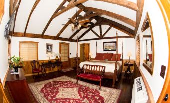 a cozy bedroom with a large bed , wooden furniture , and a red rug on the floor at The Lodges at Gettysburg