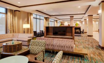 a spacious lobby with various seating options , including couches and chairs , as well as a television at Residence Inn Bangor