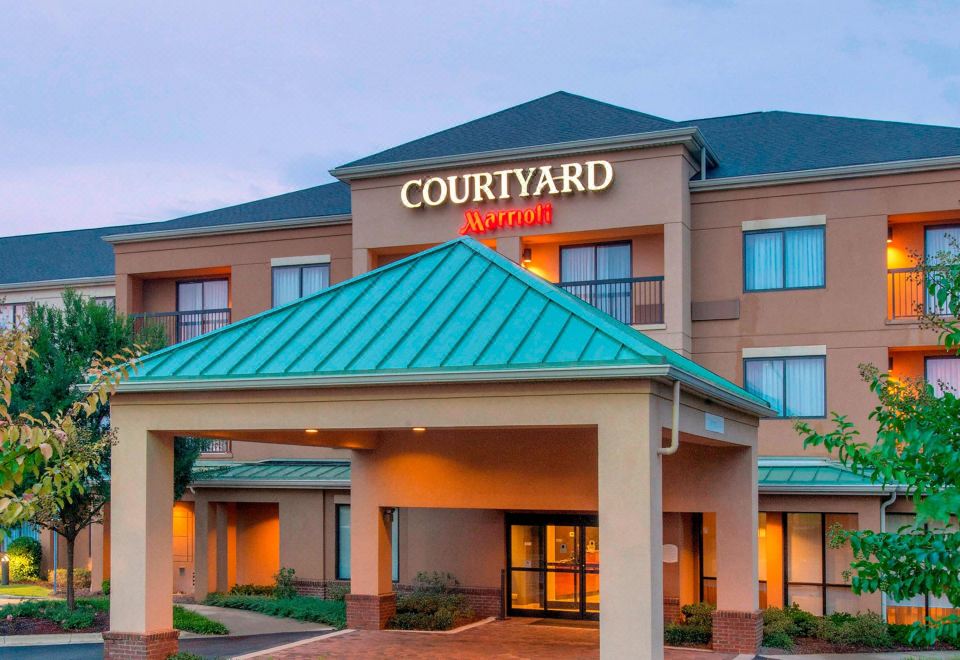 the exterior of a courtyard marriott hotel with a large sign on the front of the building at Courtyard by Marriott Montgomery Prattville