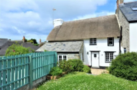 Charming  Listed Thatched Cottage with parking and short walk to sandy beach .