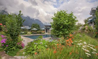 a beautiful garden with a pool surrounded by lush greenery , creating a serene and inviting atmosphere at The Himalayan