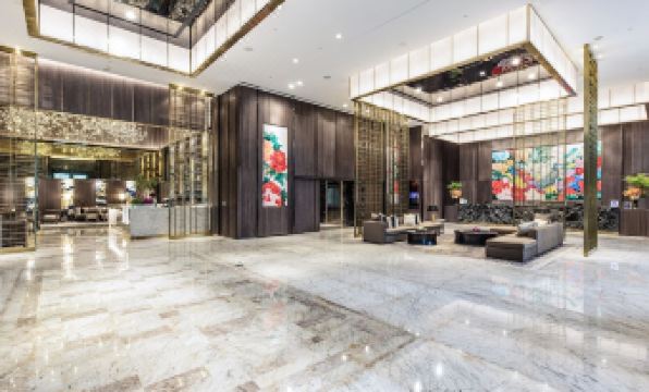 a modern hotel lobby with marble floors , high ceilings , and large windows , as well as various seating arrangements at Caesar Park Hotel Banqiao