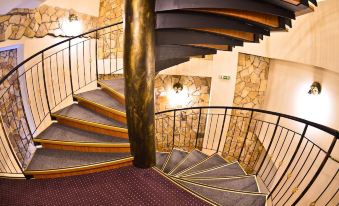 a spiral staircase with a wooden railing and metal steps leads up to a second floor at Hotel Europa