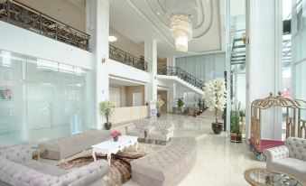 a large , modern hotel lobby with multiple couches and chairs arranged in various positions , creating a comfortable and inviting atmosphere at Savero Hotel Depok