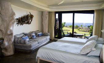 a living room with a couch and a double bed , both covered in white sheets at Nayara Hangaroa
