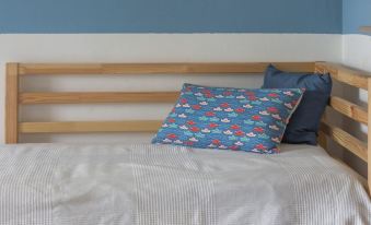 a bed with a blue and white patterned pillow is placed against a blue wall at Beach House