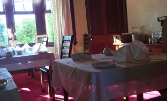 a dining room with tables covered in white tablecloths and chairs , creating a cozy atmosphere at Fox House Thirdpart Farm