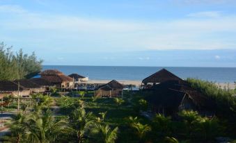 a view of the ocean with palm trees and buildings in the foreground , under a clear blue sky at Ventana Hotel