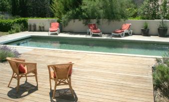 a wooden deck with lounge chairs around a swimming pool , providing a relaxing outdoor space at Holiday Home Villa Isabelle