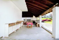 Large apartment with covered outdoor patio with table and barbecue.
