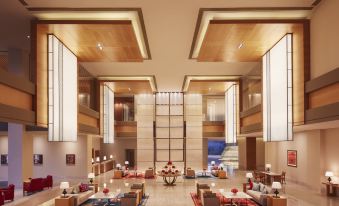 a large hotel lobby with high ceilings , wooden beams , and multiple seating areas for guests at Taj Bangalore