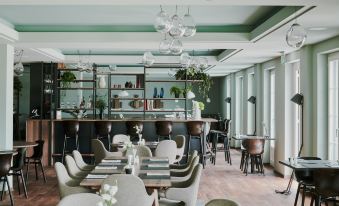 a modern restaurant with a bar area , where several people are seated and enjoying their meals at The Cambrian