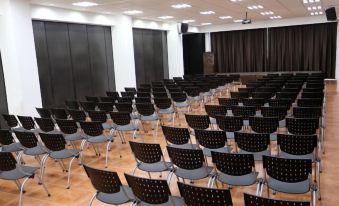 a large conference room with rows of black chairs arranged in an auditorium - style seating arrangement at Guizado Portillo Hacienda & Resort