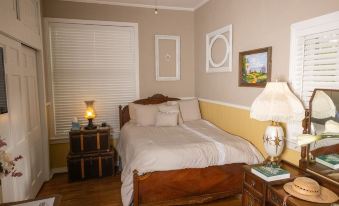 a cozy bedroom with a wooden bed , white linens , and various decorative items on the wall at Sassafras Inn