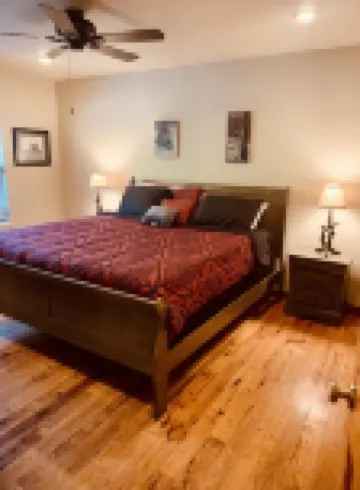 Lakeside house with fireplace, deck, and a fenced backyard with firepit.