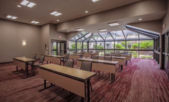 a large room with rows of tables and chairs , a skylight , and a large window at Courtyard Lincroft Red Bank