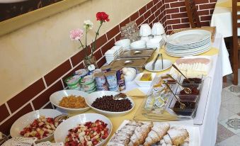 a dining table filled with a variety of food items , including pastries , sandwiches , and drinks at Comfort Hotel