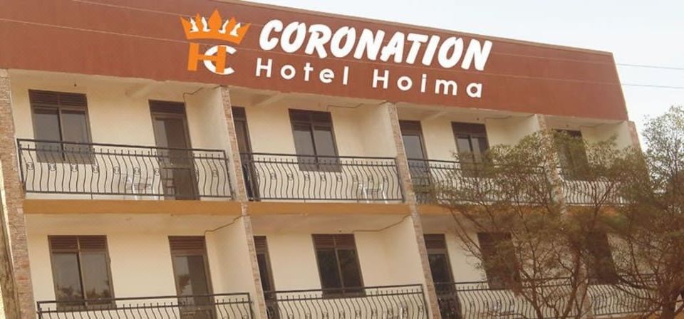 "a large building with the sign "" coronation hotel "" prominently displayed on its front , and people walking in front of it" at Coronation Hotel