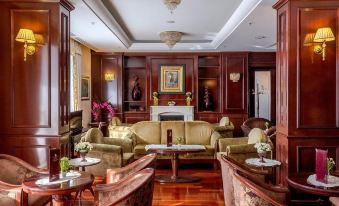 a spacious living room with wooden furniture , including a couch , chairs , and a dining table at Hotel President Solin