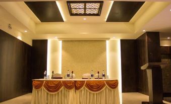 a dining room with a long wooden dining table covered in a yellow tablecloth , surrounded by chairs at Hotel Celebration