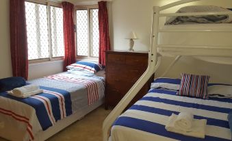 a room with two beds , one on the left and one on the right side of the room at Sailors Rest