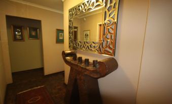 a wooden table with a mirror on it is placed in front of a wall with framed pictures at The Guesthouse