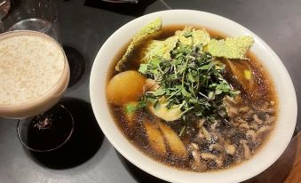 a bowl of soup with various ingredients and a glass of milk on the side at Lodges on Vashon