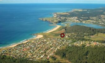 aerial view of a small town near the ocean , with a red dot indicating the location of a beach at Beachfront Apartments