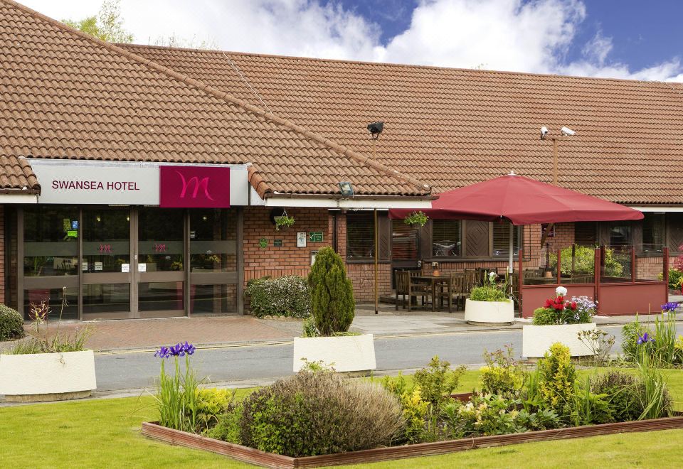 "a brick building with a sign that reads "" hotel "" prominently displayed on the front of the building" at Mercure Swansea Hotel