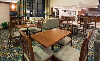 a well - lit dining room with wooden tables and chairs , creating a warm and inviting atmosphere at Staybridge Suites Milwaukee Airport South