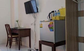 a small room with a television , a desk , and a refrigerator , as well as a bed at V at Panus