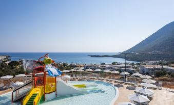 a water park with a slide and a pool , surrounded by lounge chairs and umbrellas at Atali Grand Resort