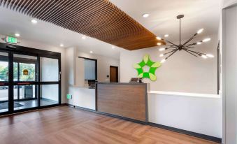 The reception desk is situated in a modern living and dining room featuring contemporary style and wooden furnishings at Extended Stay America Suites - Huntsville - Madison