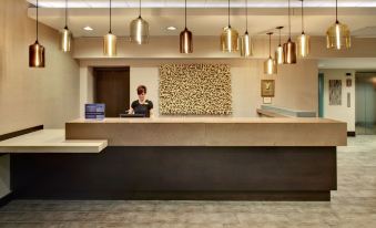 a woman standing behind a reception desk in a hotel lobby , ready to assist guests at Crowne Plaza Lombard Downers Grove