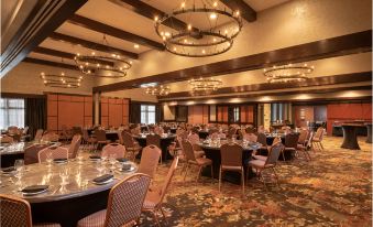 a large , elegant banquet hall filled with numerous dining tables and chairs , ready for guests to enjoy a meal at The Craftsman Inn & Suites