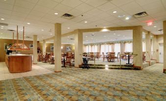 a large , empty conference room with multiple tables and chairs arranged for meetings or events at Best Western Plus Chicago Hillside