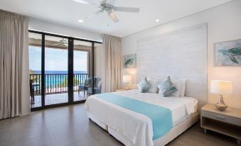 a large bedroom with a king - sized bed and a view of the ocean through a sliding glass door at Beach View Hotel