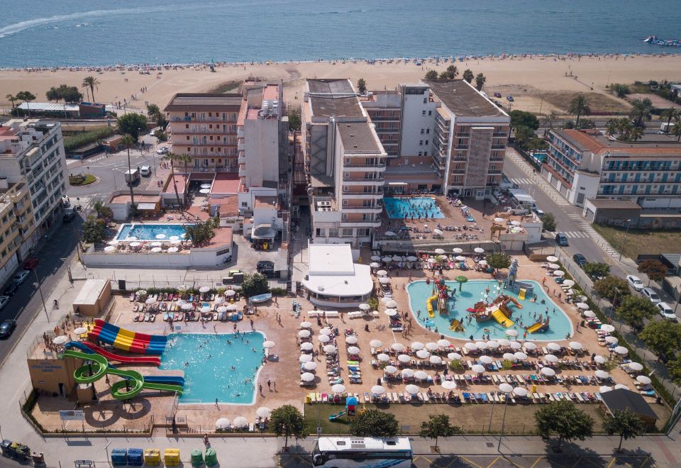 an aerial view of a large resort with multiple swimming pools , water slides , and beach chairs at Hotel Sorra Daurada Splash